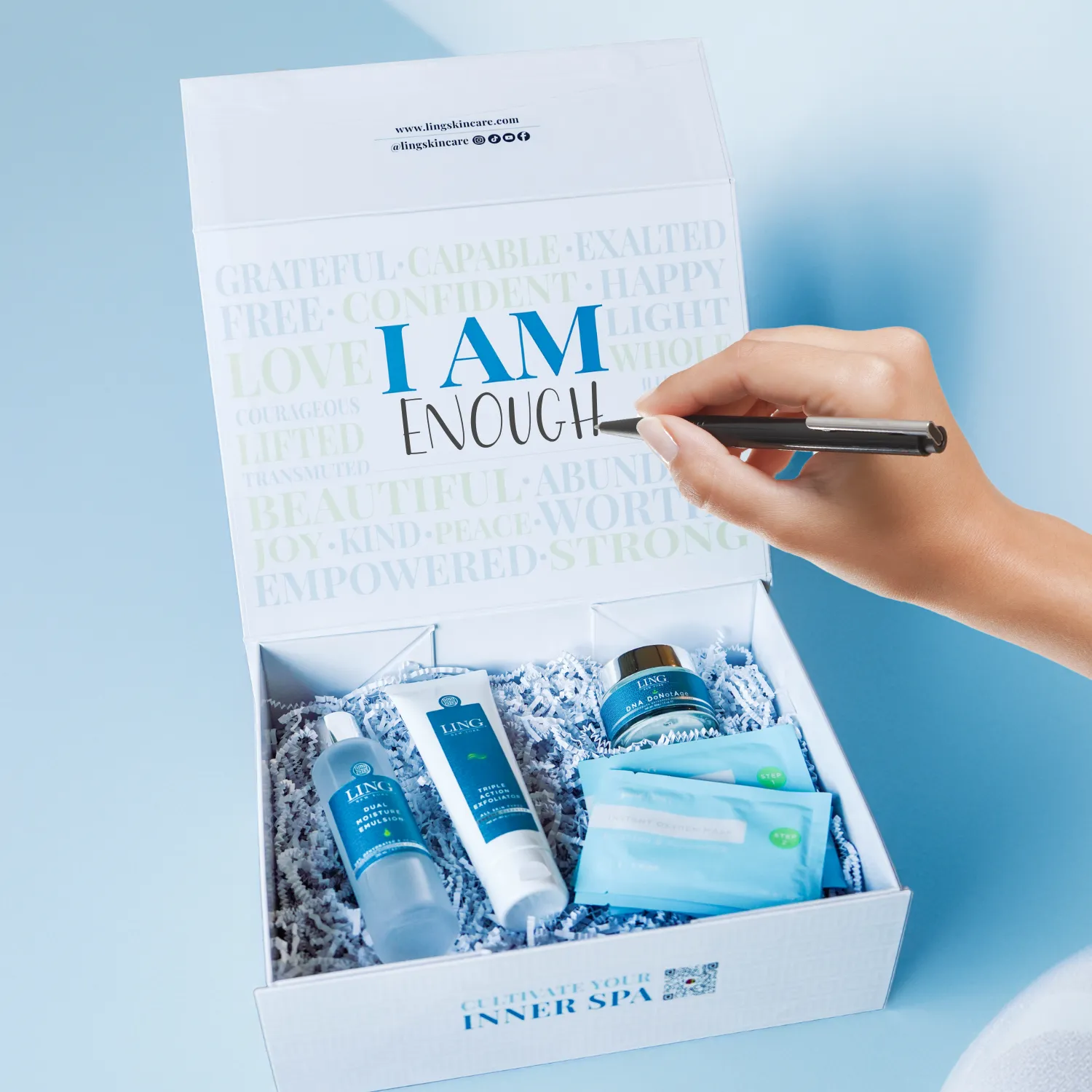 An open LING self-love box of skincare, with a hand writing I AM ENOUGH inside the lid