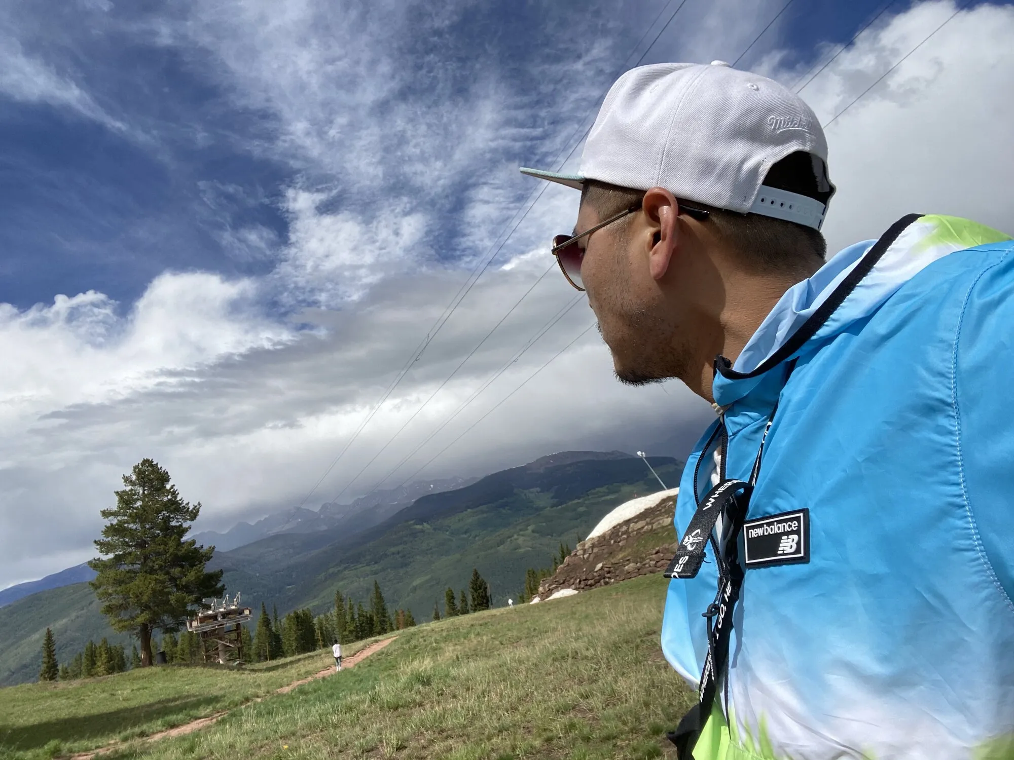 Patrick Chan in profile, looking out over green hills under a wide sky